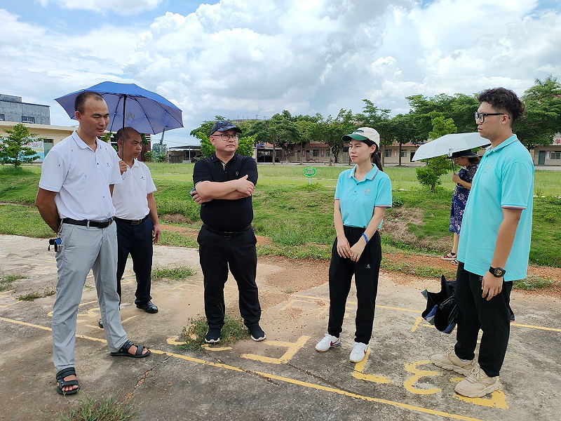梧村垌小学校长为优石丽总经理陈文定介绍学校运动场环境图